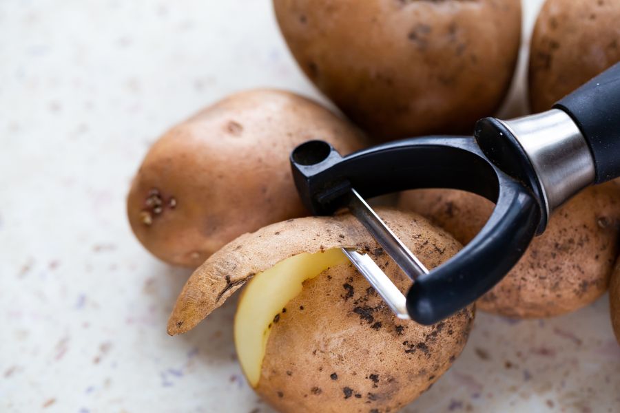 Pelar patatas con un pelador de verduras