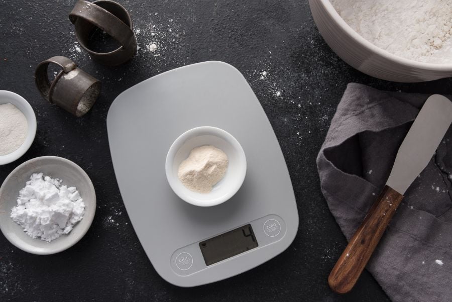 Medición de ingredientes para hornear en una báscula para alimentos